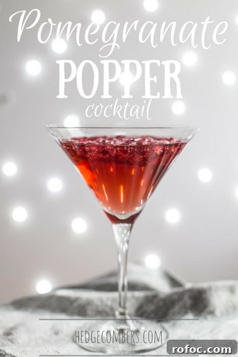 Sparkling Pomegranate Popper Cocktail Recipe for Parties 2 A cocktail glass of Pomegranate Popper Cocktail on a silver cloth