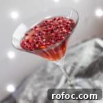Sparkling Pomegranate Popper Cocktail Recipe for Parties 6 cocktail glass with pomegranate popper cocktail and pomegranate seeds against a sparkly grey background