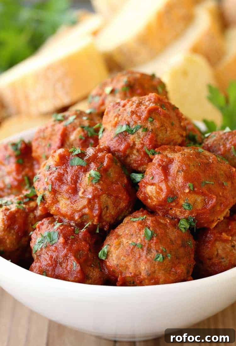 Sunday-Style Grandma’s Meatballs with Savory Tomato Sauce 9 Grandma's Sunday Meatballs and Sauce close up in a white bowl with bread