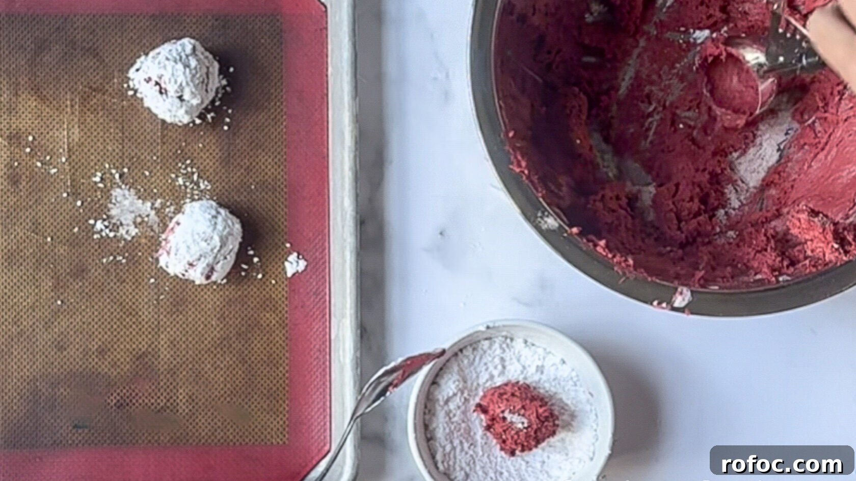 rolling small cookie dough balls in powdered sugar before putting them on a pan.