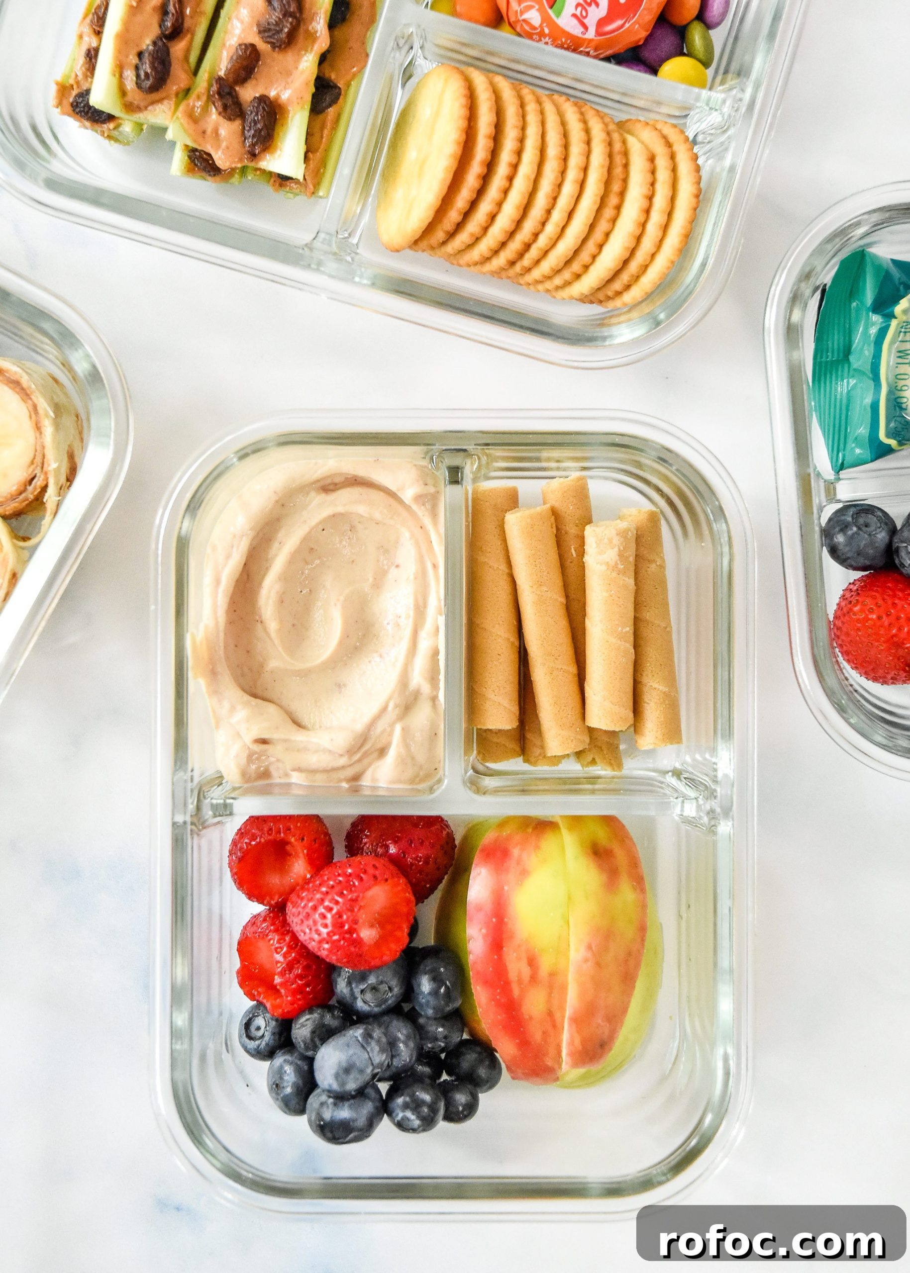 peanut butter yogurt dip with fruit and wafers in a glass meal prep container.