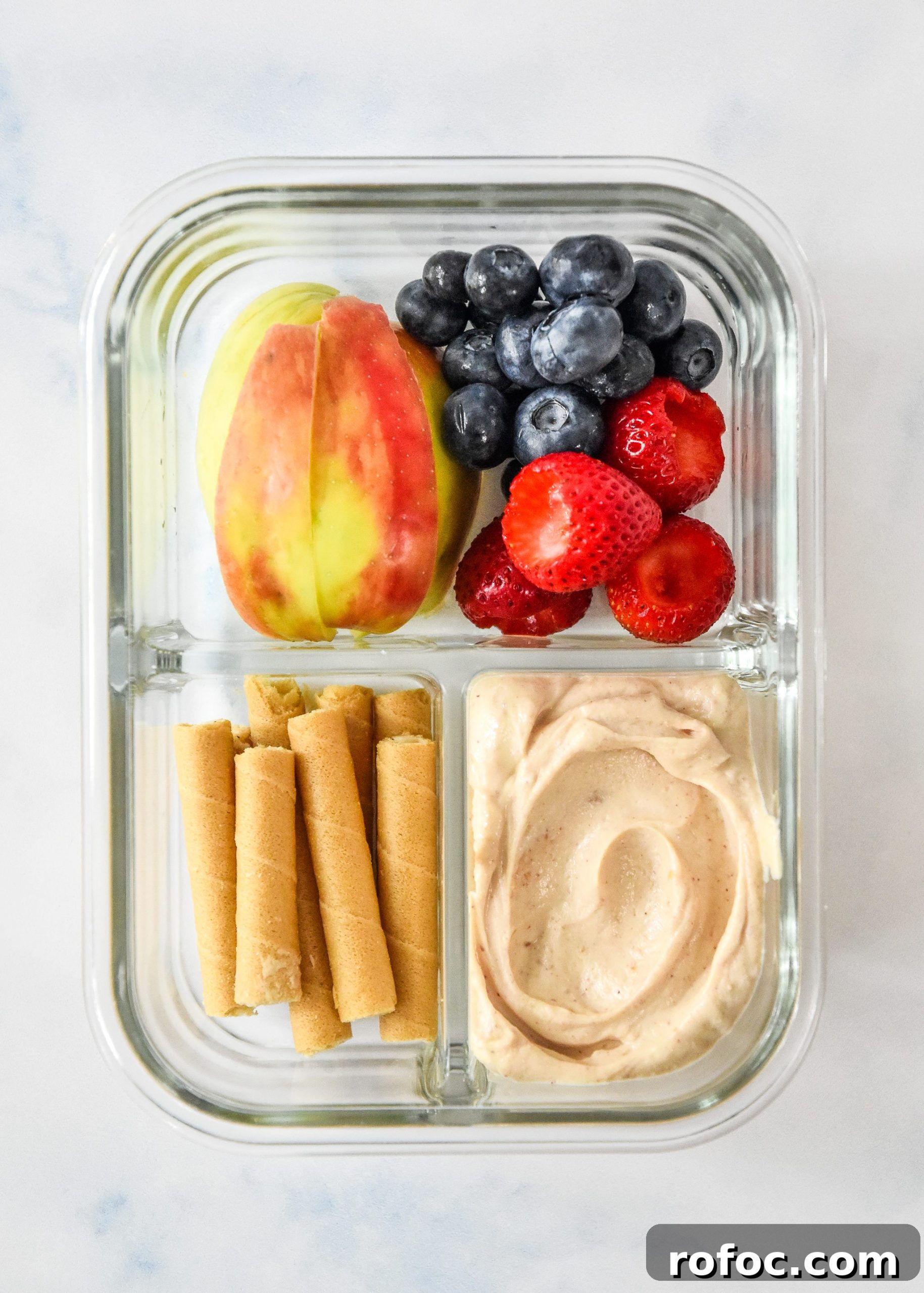 peanut butter fruit dip yogurt snack box with apple slices, berries and dip.
