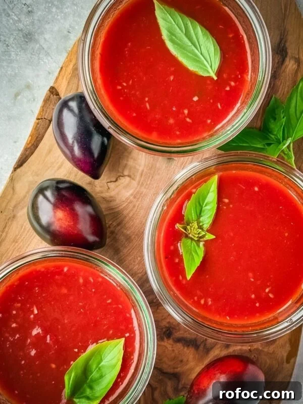 Mason jars with midnight Roma tomato sauce on a wooden board.