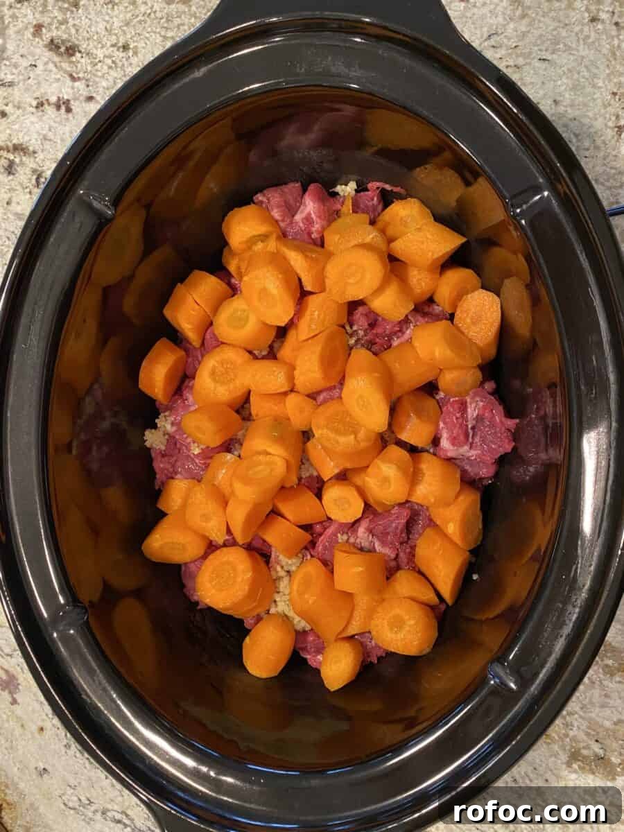 Traditional Irish Beef Stew Recipe for Hearty Weeknight Dinners 10 Carrots on top of beef in a crockpot.
