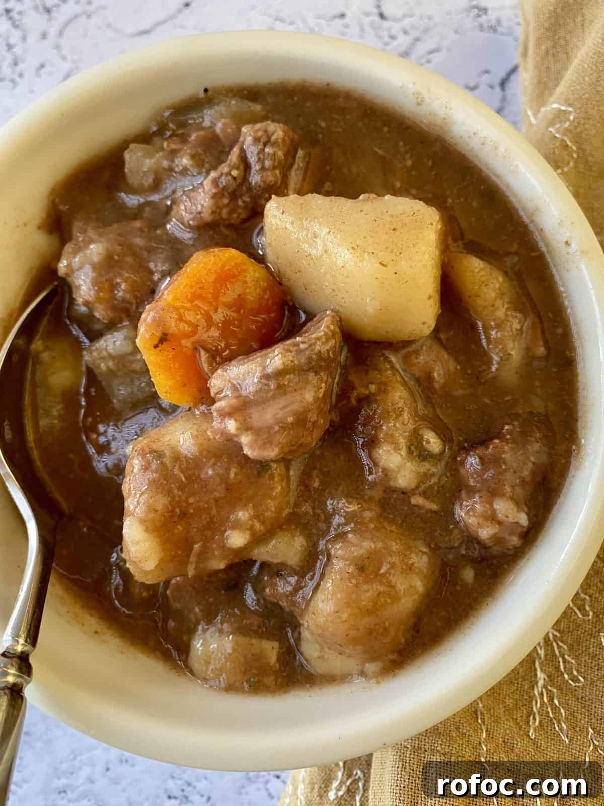 Traditional Irish Beef Stew Recipe for Hearty Weeknight Dinners 4 A small bowl full of St. Patrick's Day Stew with a spoon and napkin on the side.