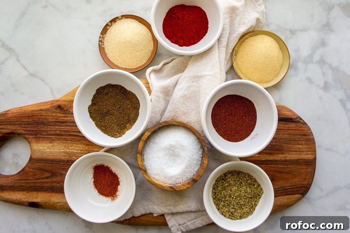 ingredients to making ground beef taco seasoning in small white bowls including chili powder, smoked paprika, onion powder, garlic powder, cayenne, oregano, and salt.