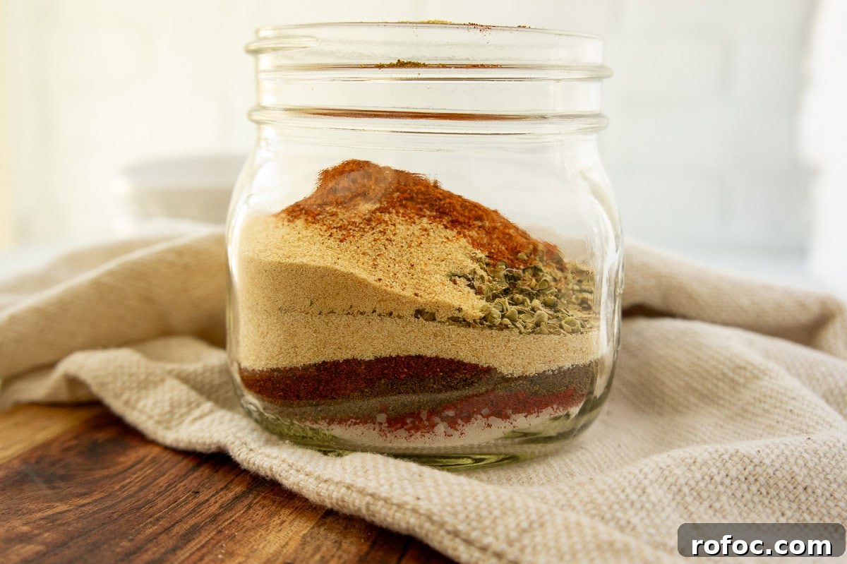a mason jar with layers of spices inside.