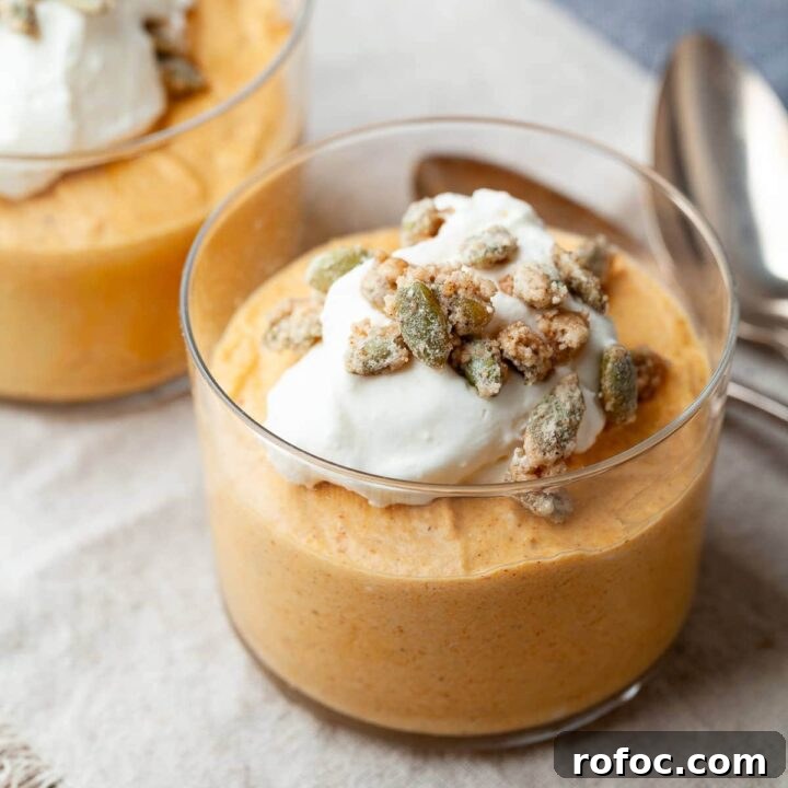 gluten free pumpkin mousse in small cups topped with whipped cream and candied pumpkin seeds. the perfect no bake dessert