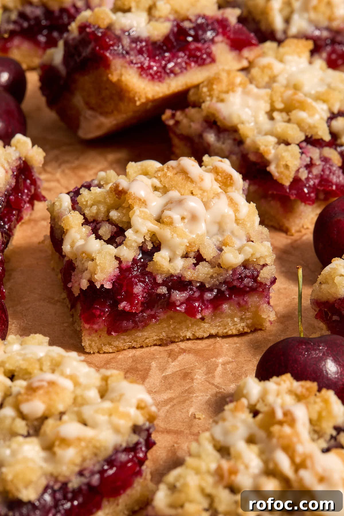 Almond Flour Cherry Pie Bars Recipe — Tender Cherry Dessert Bars 2 Side view of cherry bars on a sheet of brown parchment.