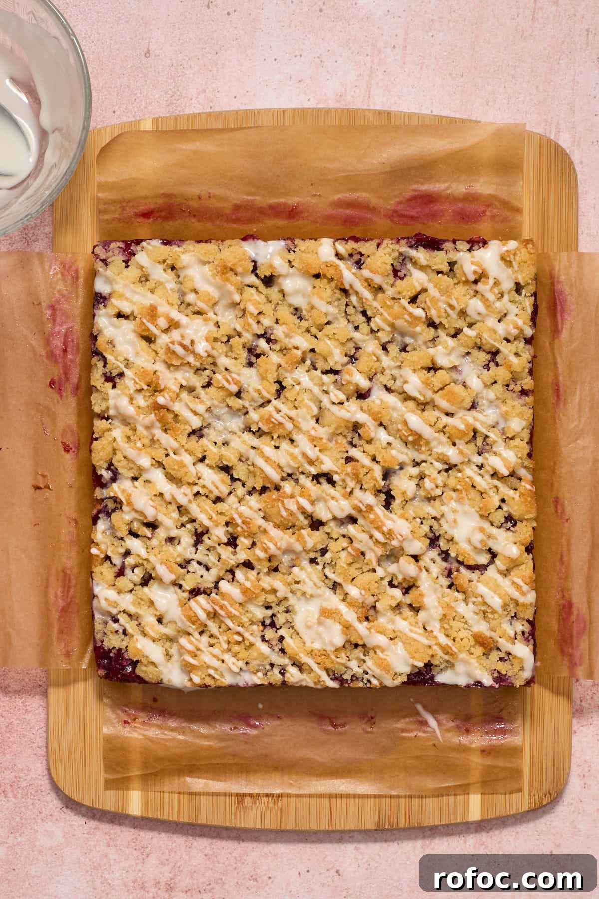 Almond Flour Cherry Pie Bars Recipe — Tender Cherry Dessert Bars 13 Bars on a wooden board with powdered sugar glaze drizzled over top.