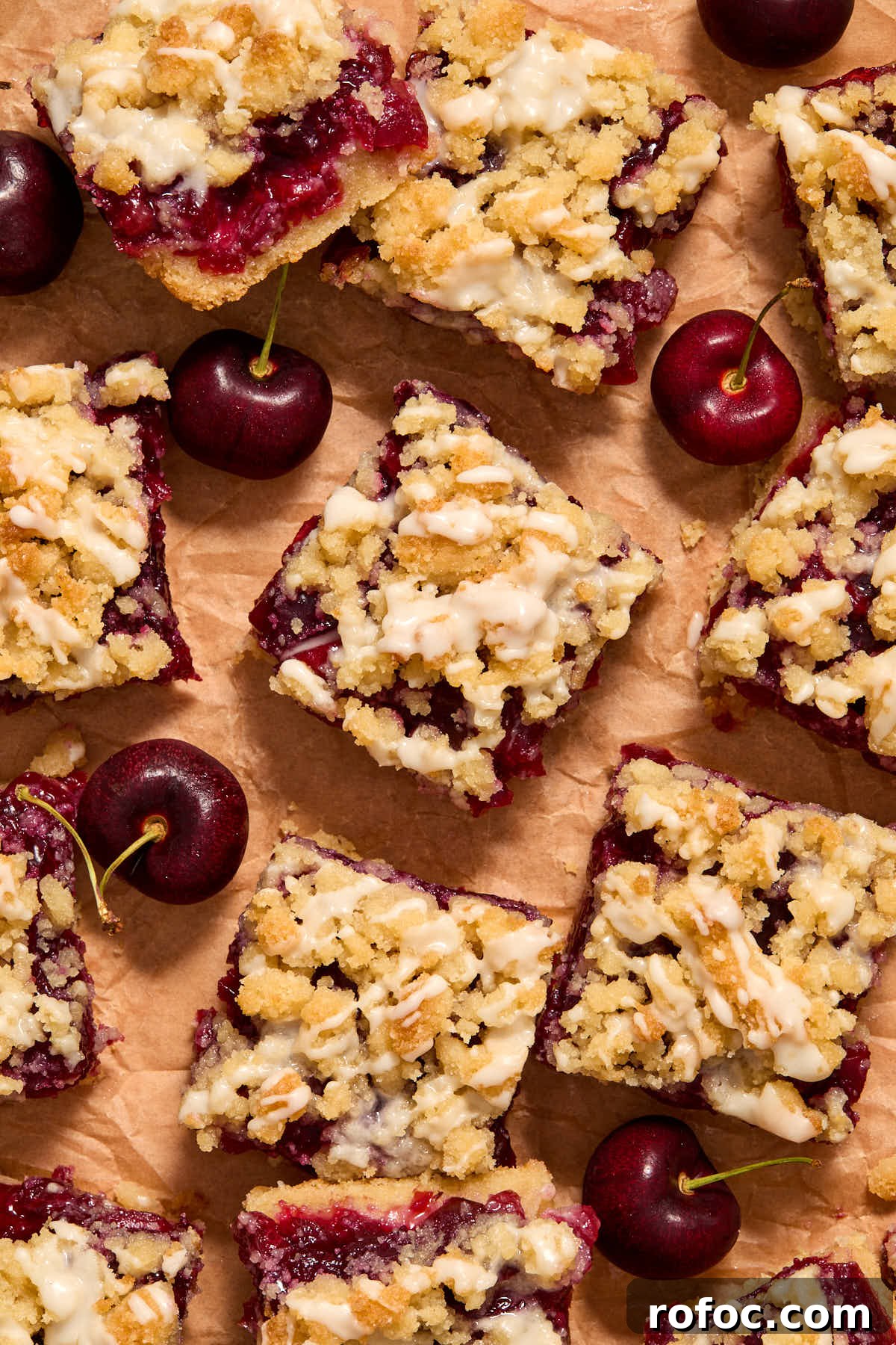 Almond Flour Cherry Pie Bars Recipe — Tender Cherry Dessert Bars 14 Overhead view of cherry pie bars arranged on brown parchment paper.