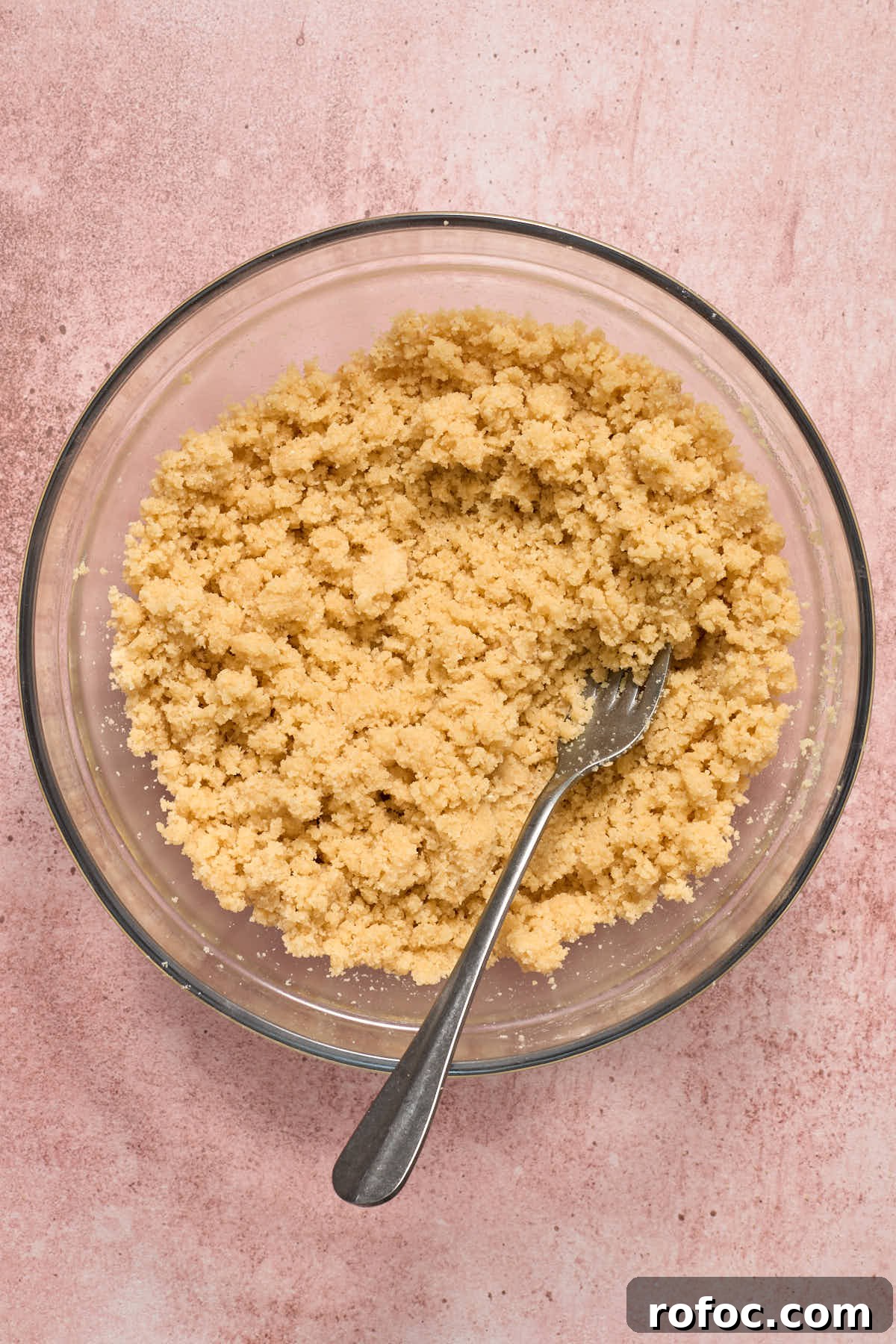 Almond Flour Cherry Pie Bars Recipe — Tender Cherry Dessert Bars 4 Crust and topping mixture in a glass bowl with a fork.