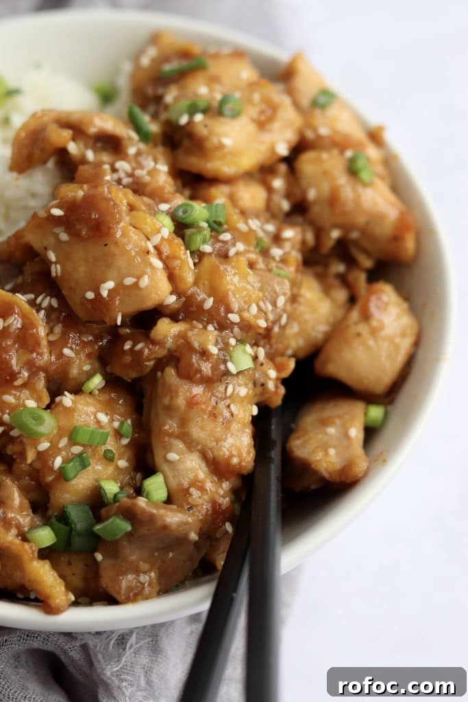 Crispy Sesame Chicken Recipe with Sticky Sweet Sauce 5 Close up shot of sticky sesame chicken with chopsticks