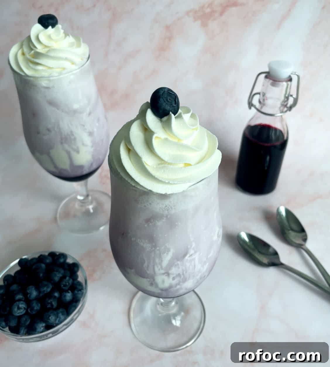 blueberry italian sodas with whipped cream swirrled on top.