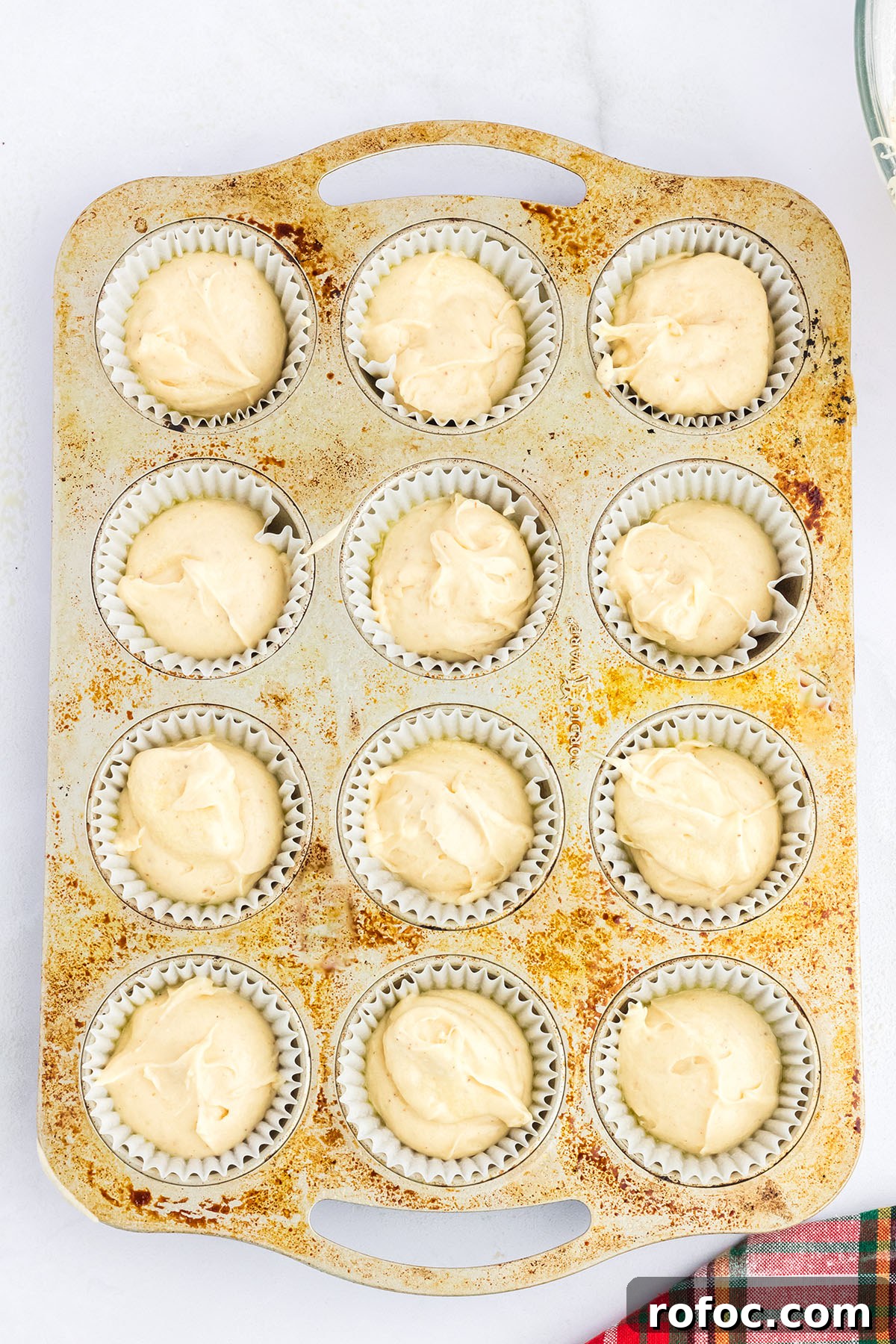 Eggnog Cupcakes with Spiced Rum Buttercream Filling 6 Eggnog cupcake batter scooped into a muffin pan.