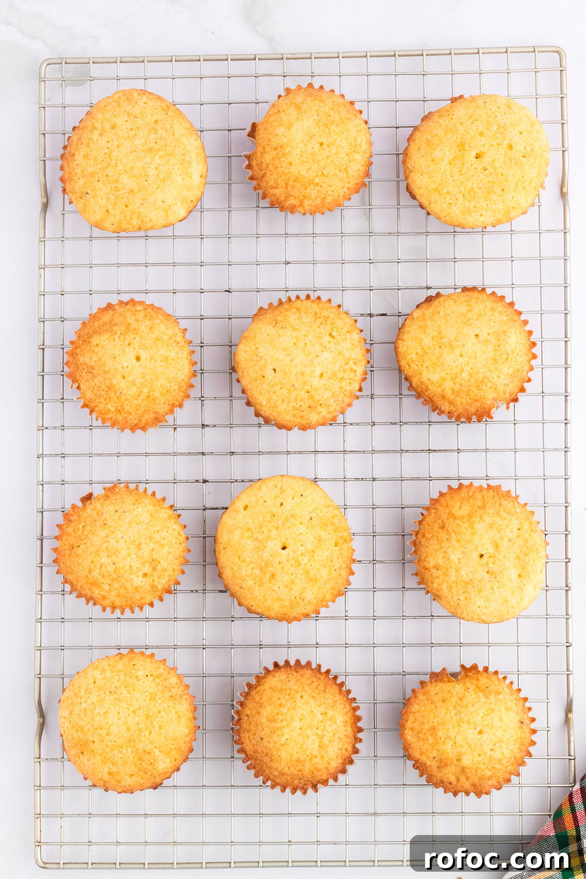 Eggnog Cupcakes with Spiced Rum Buttercream Filling 7 Eggnog cupcakes cooling on a wire rack.