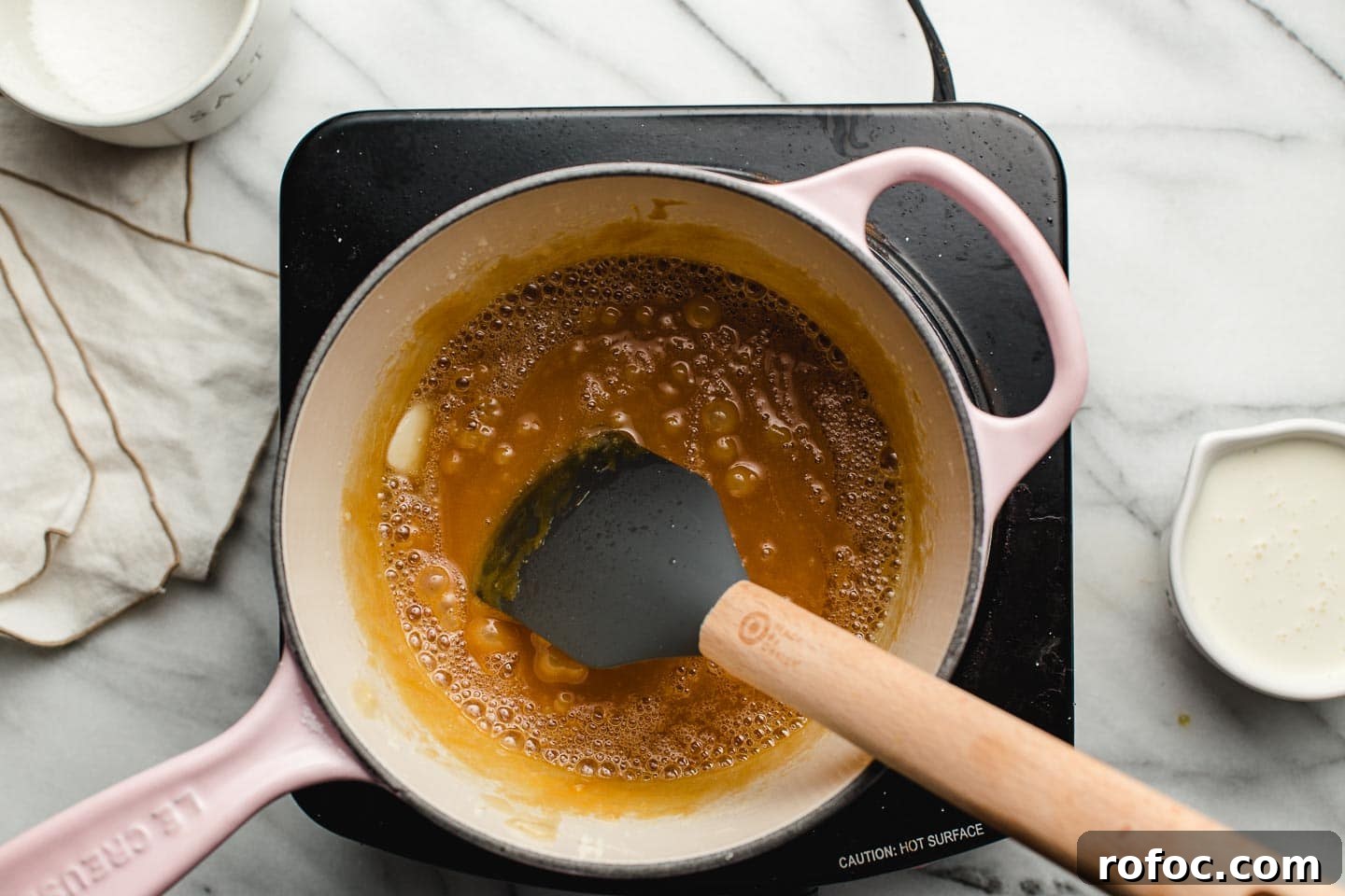 How to Make Homemade Salted Caramel Sauce at Home 5 Adding butter to browned sugar in a saucepan.