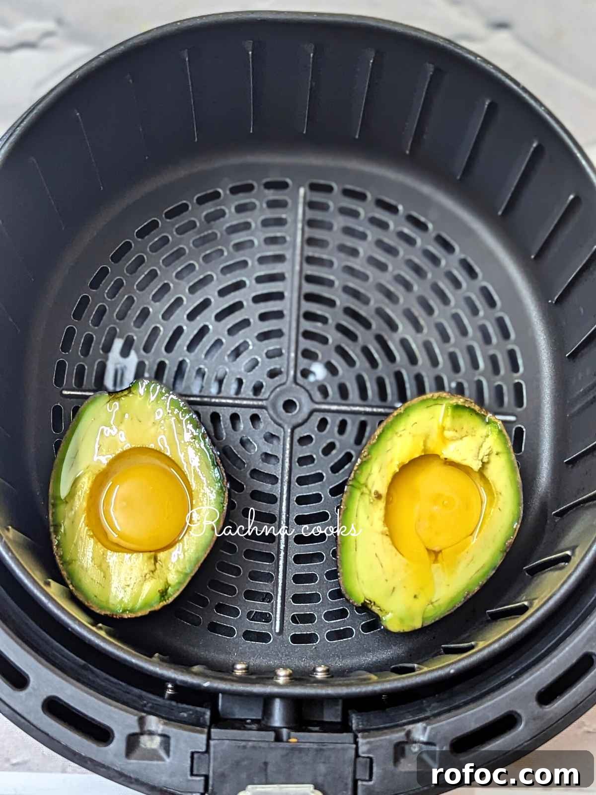 Crispy Air Fryer Avocado Eggs: Quick Breakfast Recipe 6 2 avocado eggs ready for air frying in air fryer basket.