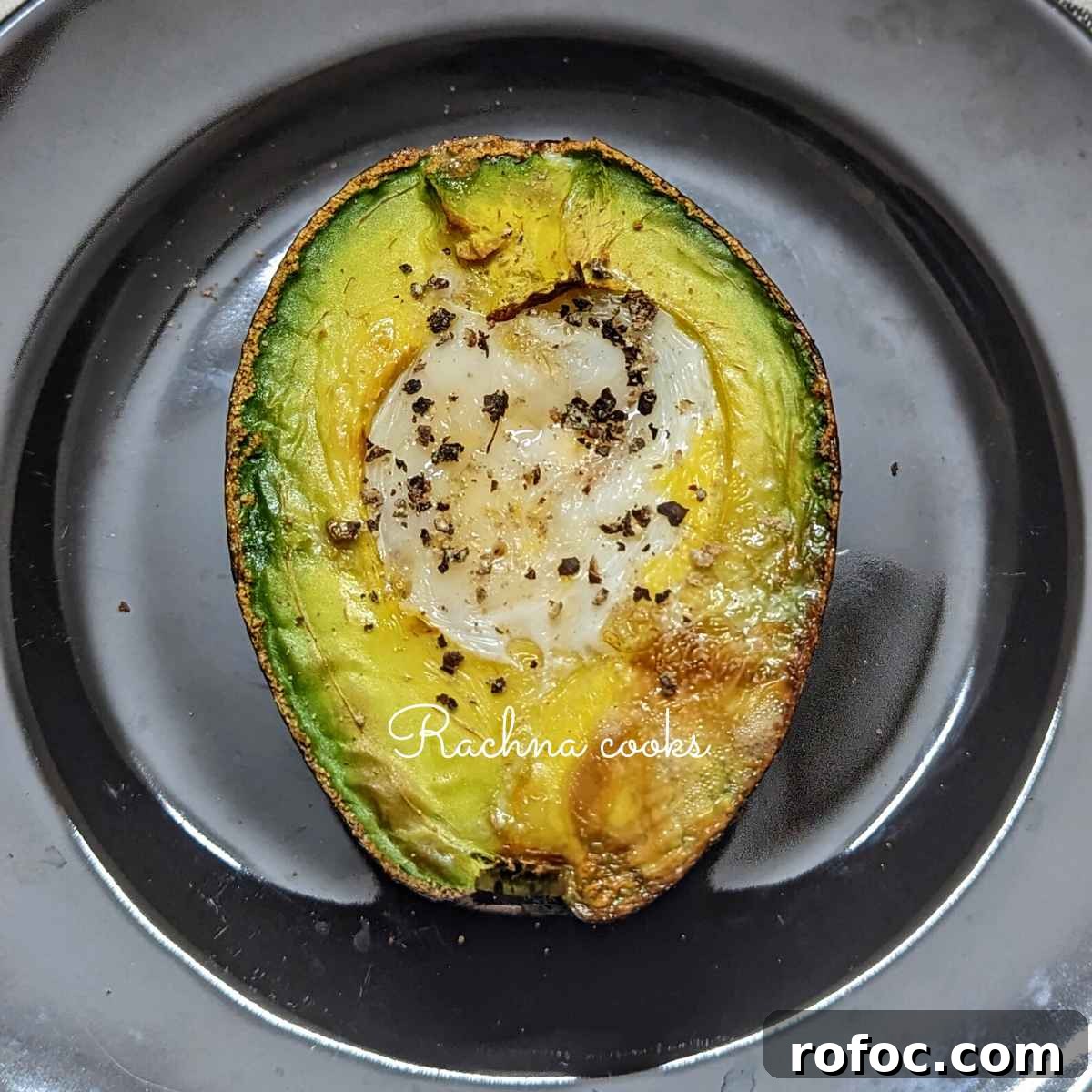 Crispy Air Fryer Avocado Eggs: Quick Breakfast Recipe 7 Avocado egg on a black plate