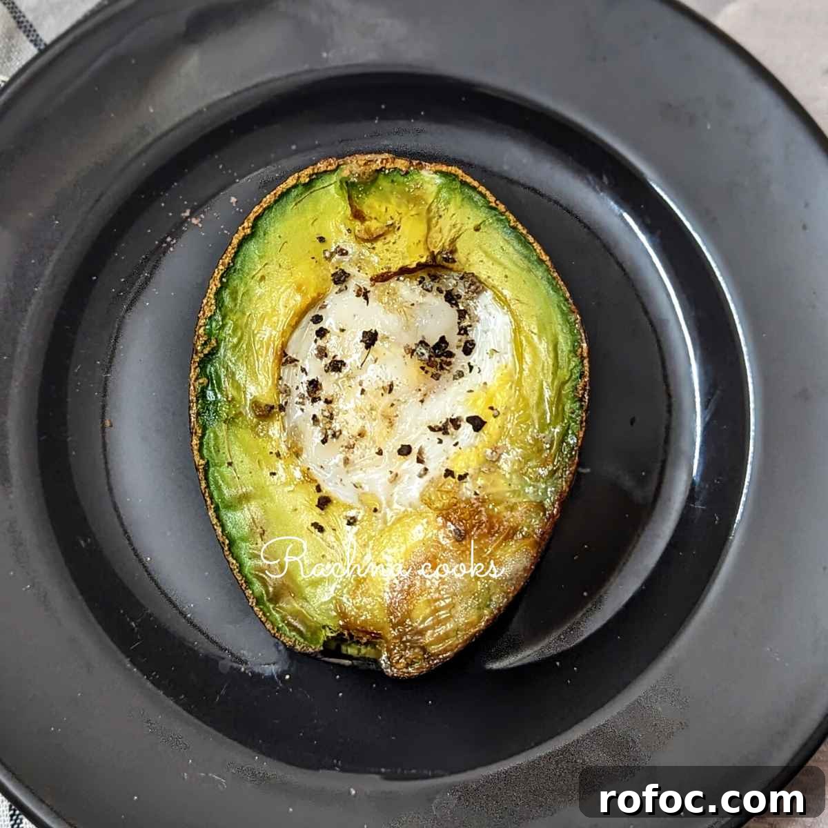 Crispy Air Fryer Avocado Eggs: Quick Breakfast Recipe 8 Avocado egg on a black plate