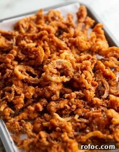 Crispy Fried Onions fried onions fresh out the fryer on baking tray