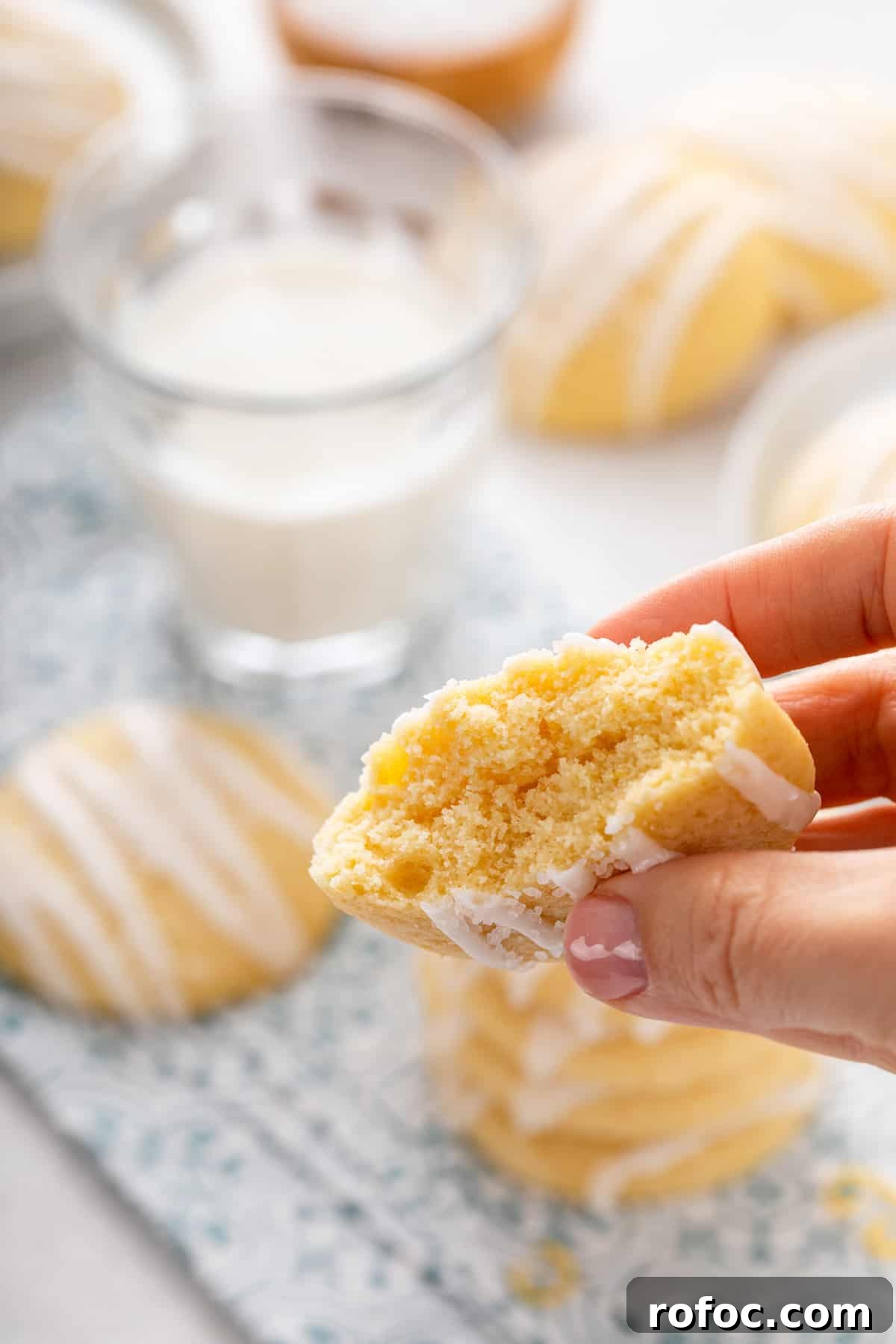 Hand holding up a pound cake cookie that is broken in half to show the inner texture.