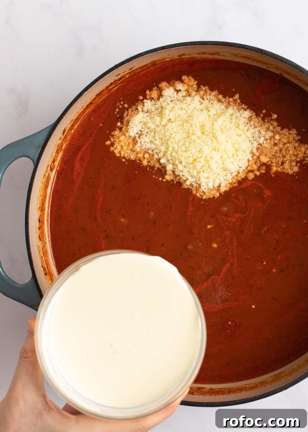 Simple Homemade Tomato Soup Recipe for Rich Flavor 6 tomato soup ingredients in dutch oven with parmesan and heavy cream