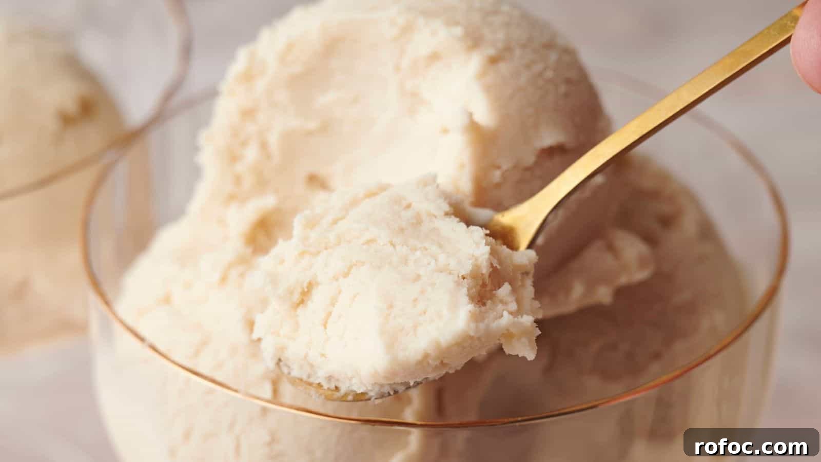 35 Gameday Recipes That Always Crowd-Pleasers Love 30 A gold spoon scoops a portion of creamy, pale vanilla ice cream from a glass bowl.