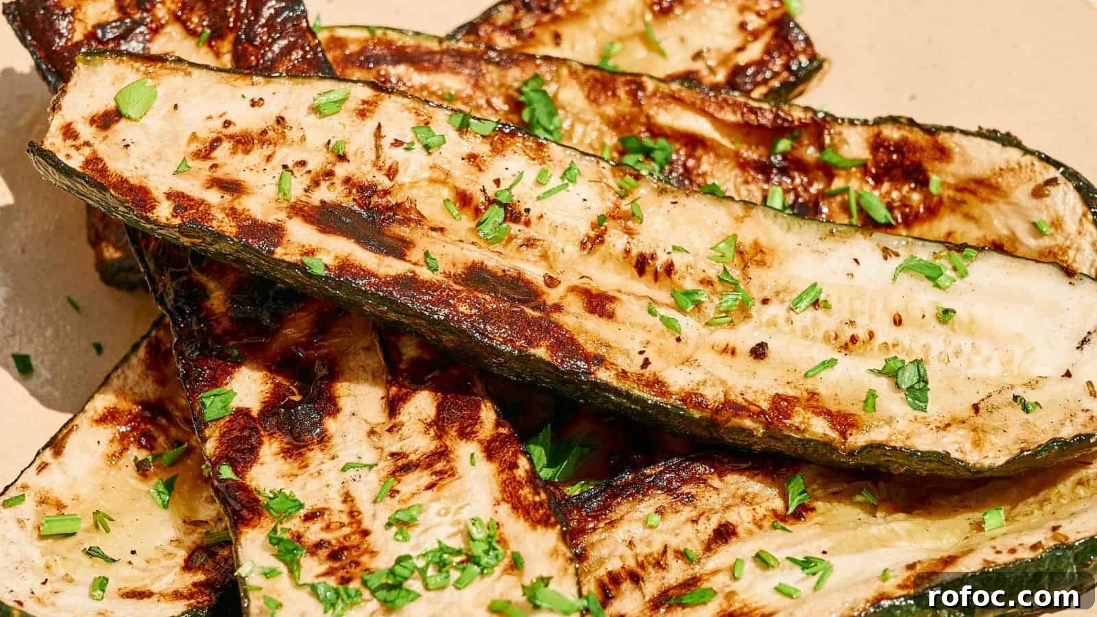 35 Gameday Recipes That Always Crowd-Pleasers Love 34 Grilled zucchini slices garnished with chopped herbs on a light-colored plate.
