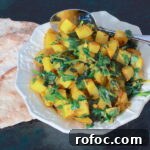 Aloo Palak Recipe: Flavorful Indian Spinach and Potato Curry 4 Bowl of Aloo Palak with a cut up flatbread