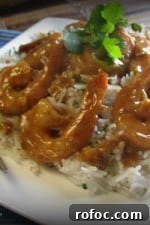 Plate of almond glazed shrimp over a bed of rice.