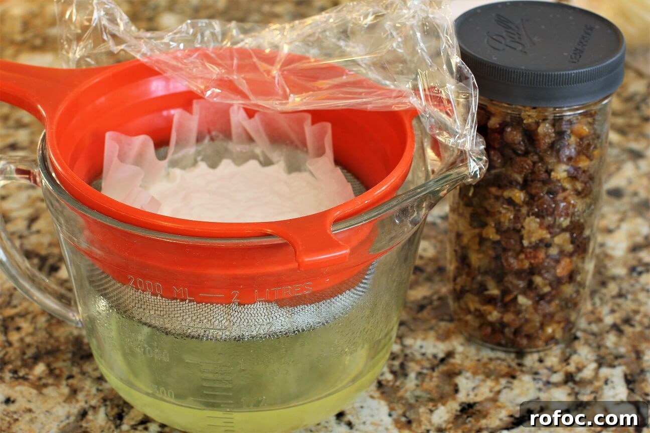 Quarkstollen: A Faster Take on Classic German Christmas Stollen 4 yogurt straining in strainer and raisins and peel in a jar
