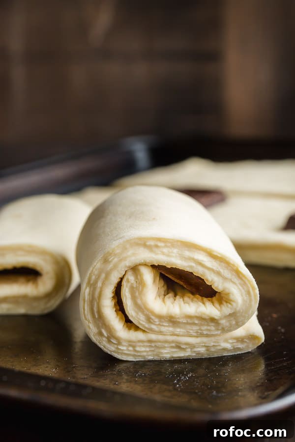 Classic Pain au Chocolat Recipe: How to Make Flaky Chocolate Croissants 7 Croissant dough wrapped around chocolate bar ready to proof