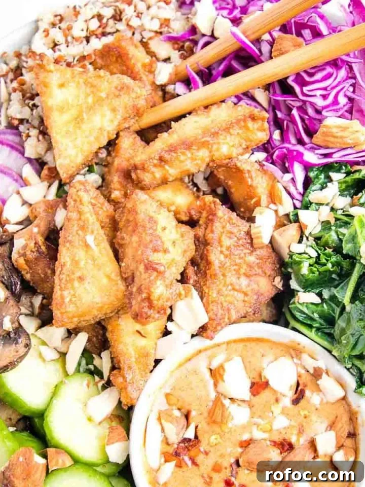 Crispy tofu pieces in a bowl with veggies and peanut dipping sauce.