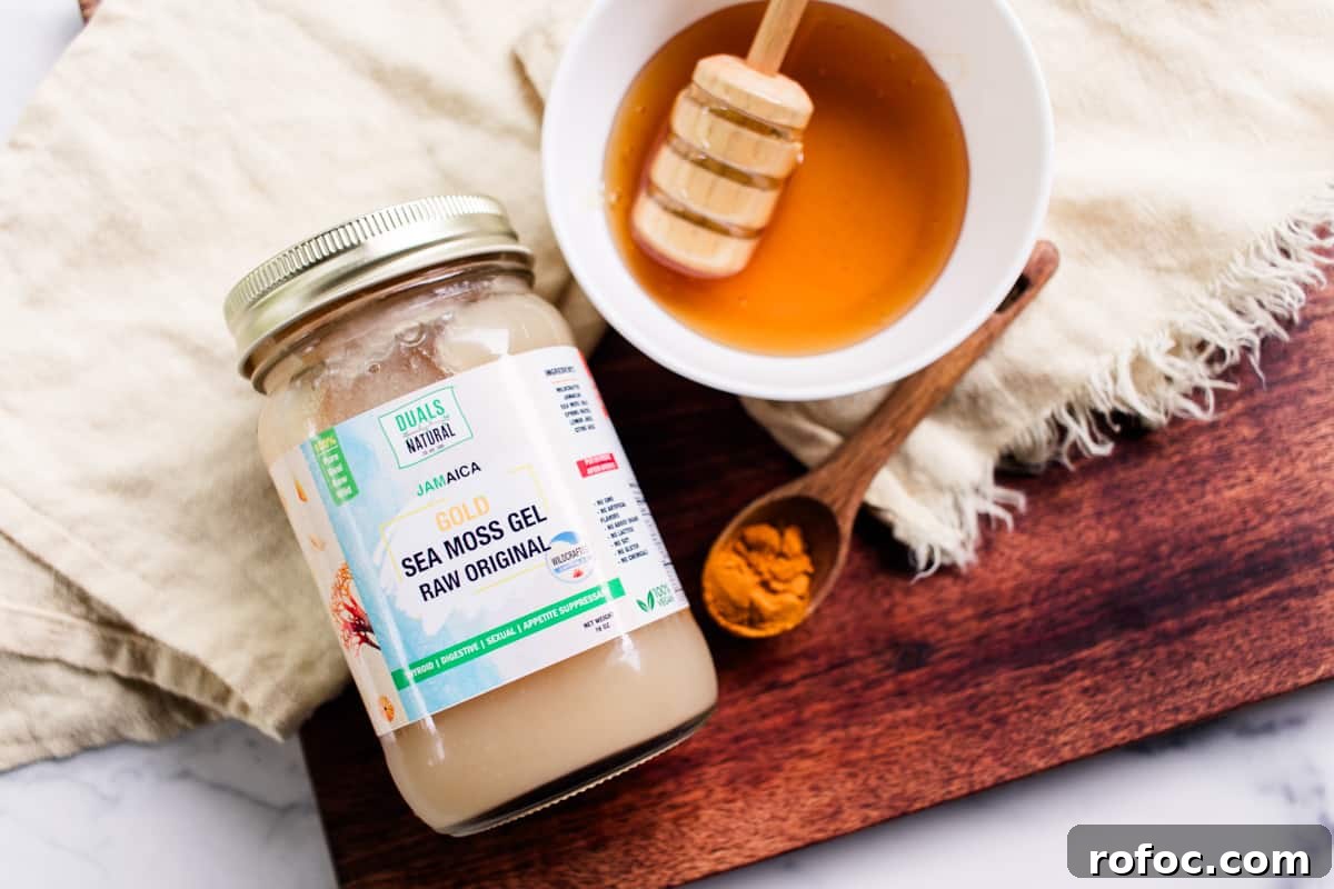 DIY Gel Sea Moss Face Mask Recipe for Glowing Skin 4 Sea moss gel, honey and turmeric ingredients on a marble table ready to make a face mask.