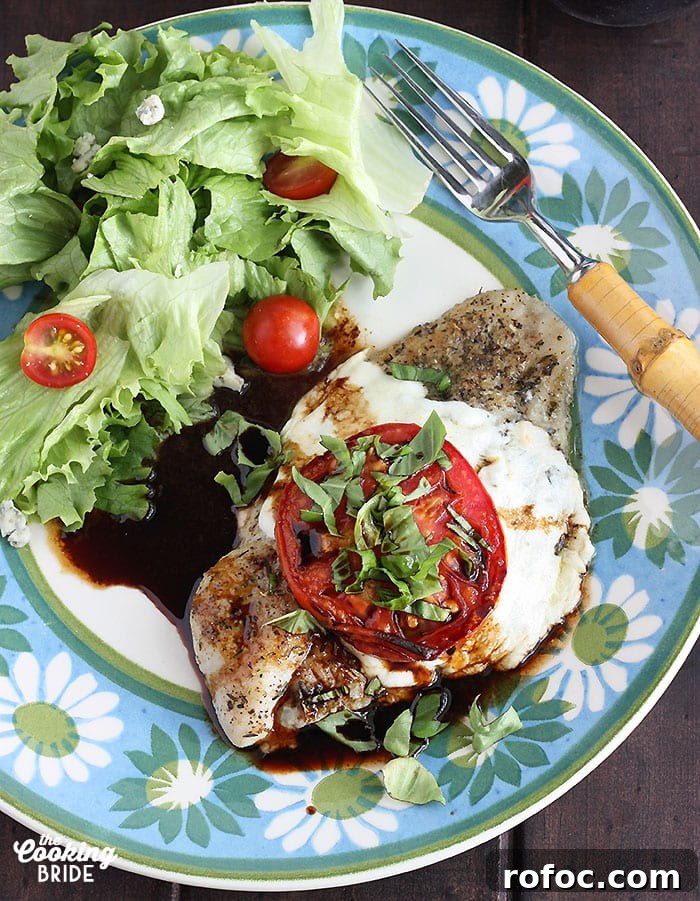 Caprese-Style Baked Catfish Fillets with Tomato and Mozzarella 8 Caprese baked catfish fillet and a simple salad on a blue and green floral plate with a fork on the side