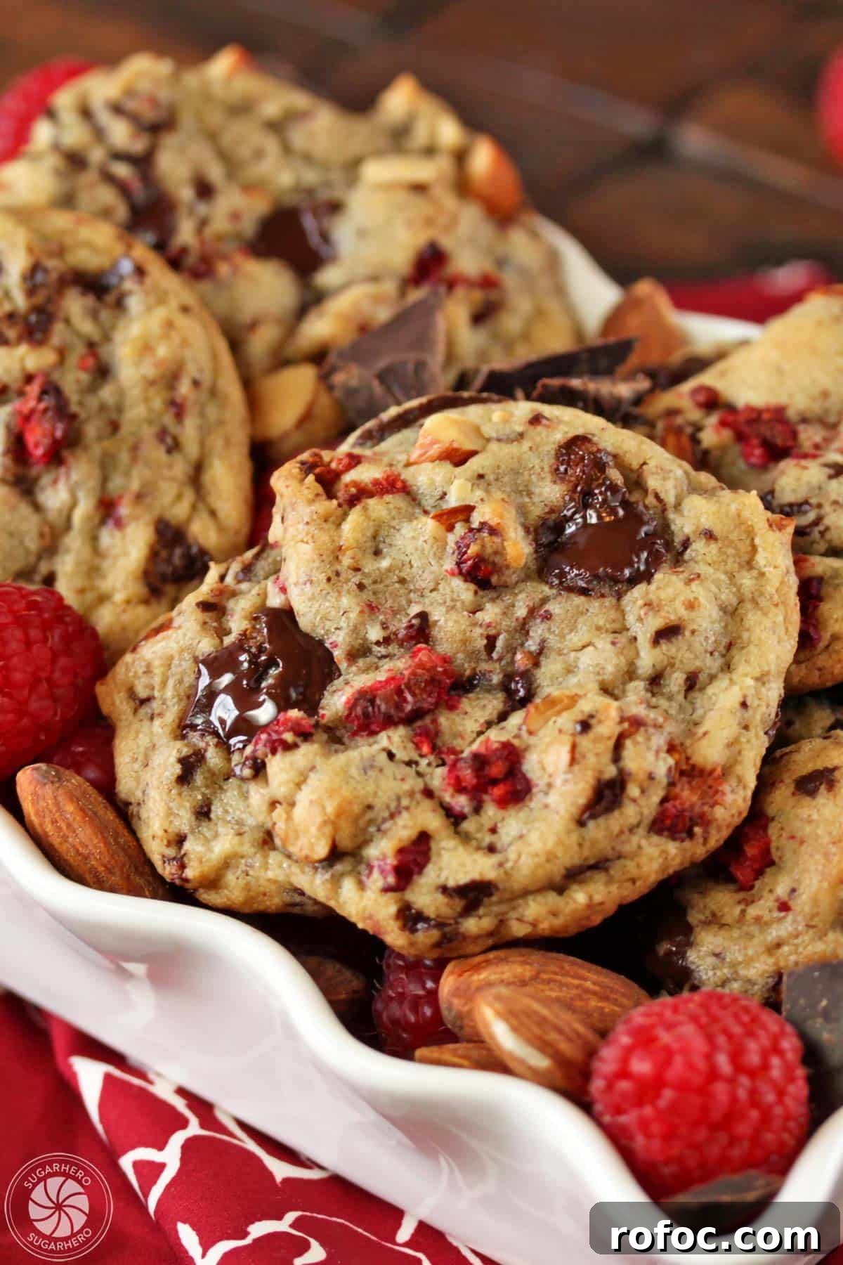 Raspberry Almond Chocolate Chunk Cookies - soft almond-flavored cookies with tangy dried raspberries and chocolate chunks. Raspberry Almond Chocolate Chunk Cookies - close-up shot of the cookies with chocolate chunks and raspberries. | From SugarHero.com