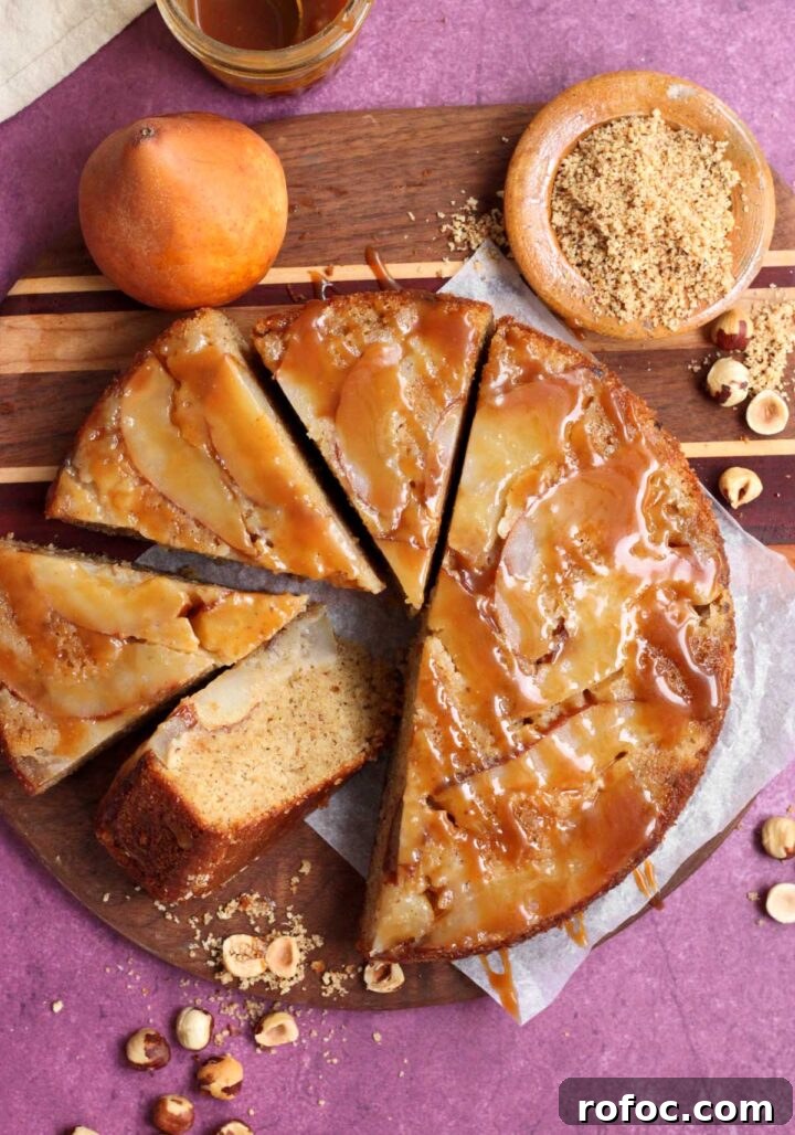 brown butter hazelnut pear upside down cake sliced on cutting board