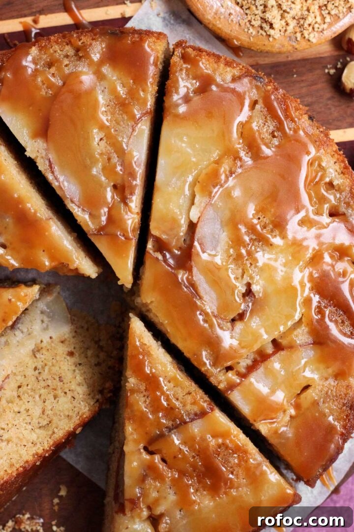 brown butter hazelnut pear upside down cake sliced on cutting board