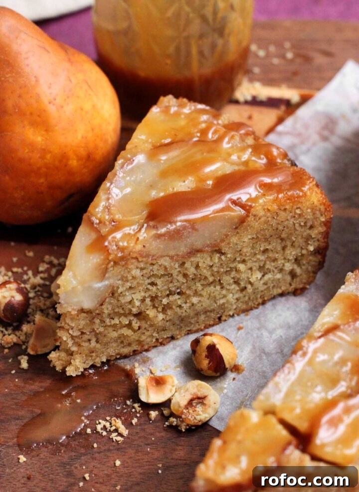 brown butter hazelnut pear upside down cake slice with caramel sauce