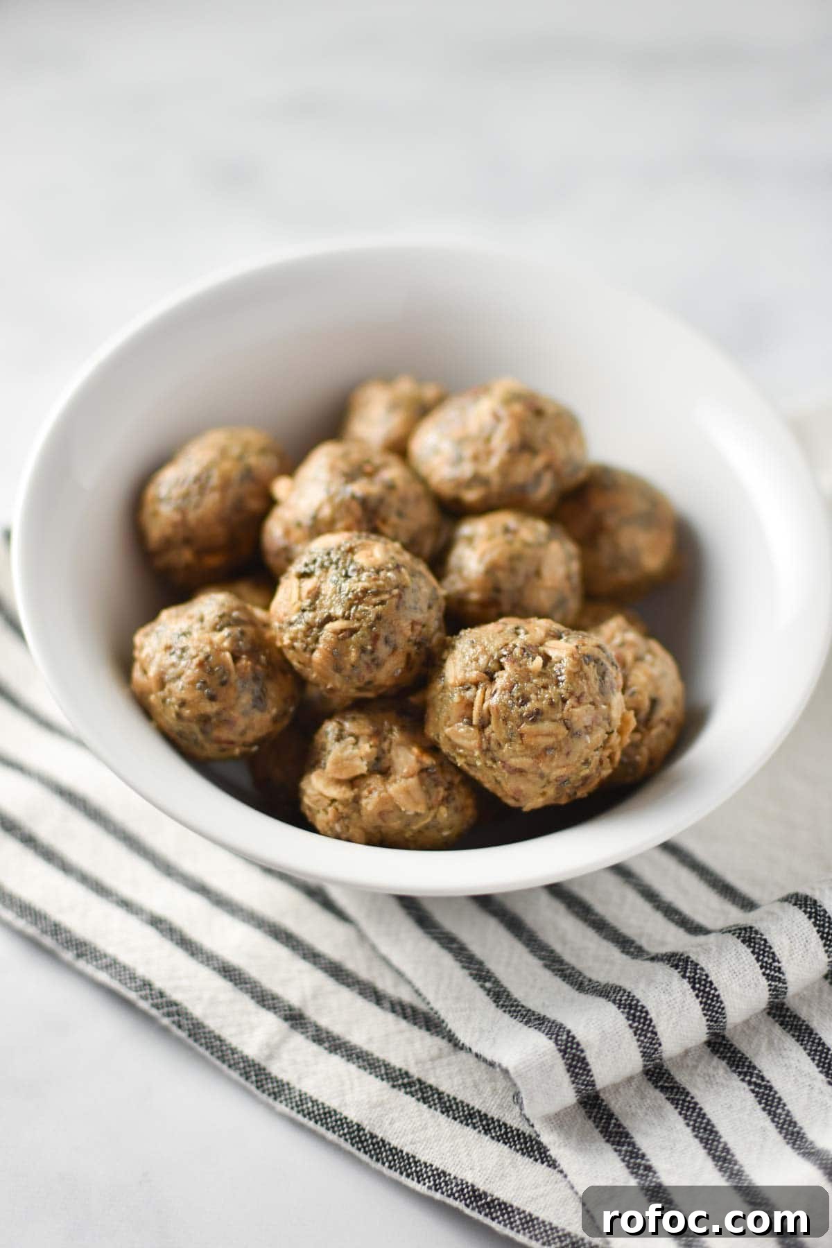 Sunflower Butter Energy Balls — Gluten- and Nut-Free Snacks 2 A bowl of sunbutter balls with oats and chia on a striped towel