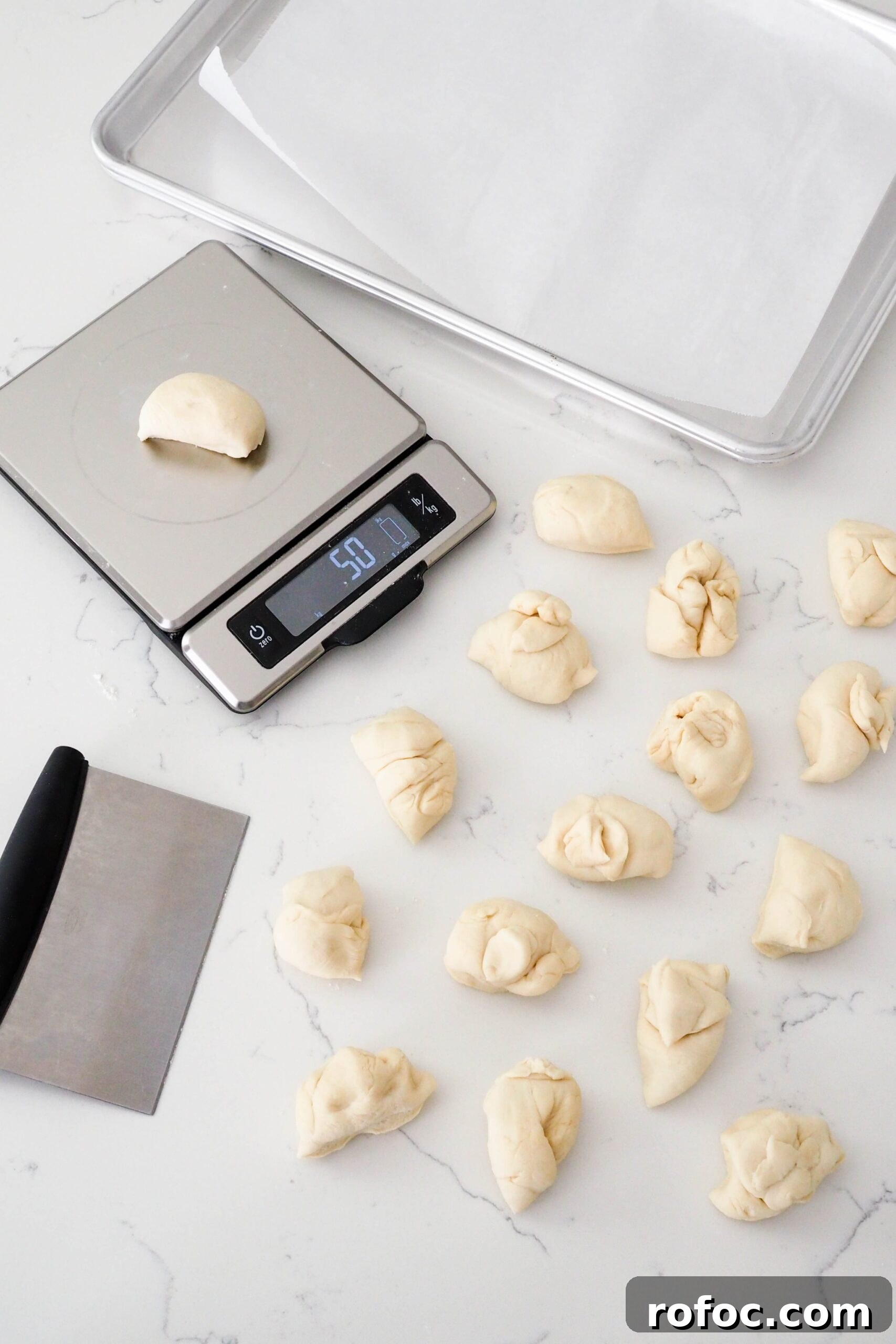 Crispy Garlic Breadsticks Recipe with Herb Butter Dip 8 16 pieces of enriched dough are divided on a counter.