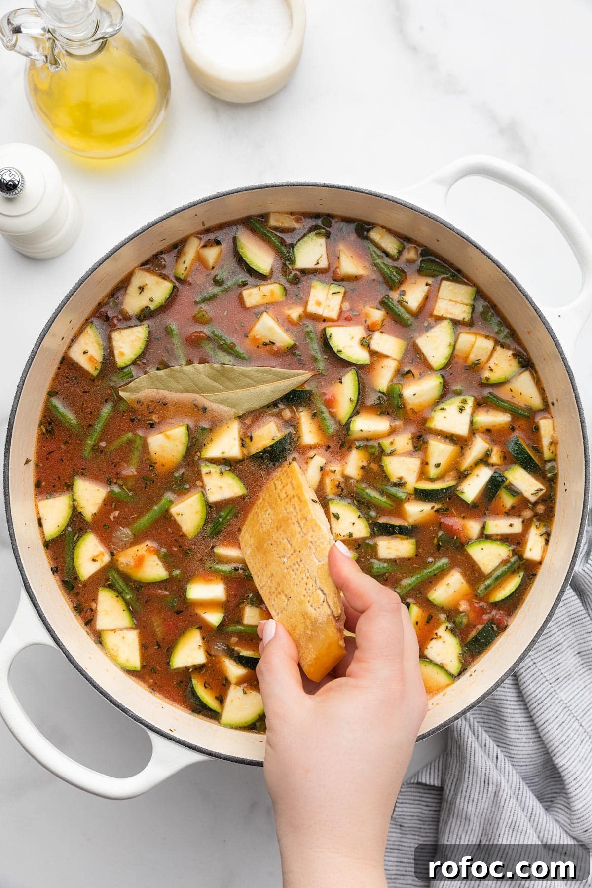 Classic Italian Minestrone Soup Recipe for Cozy Weeknight Dinners 12 adding a parmigiano reggiano rind to an uncooked pot of minestrone soup