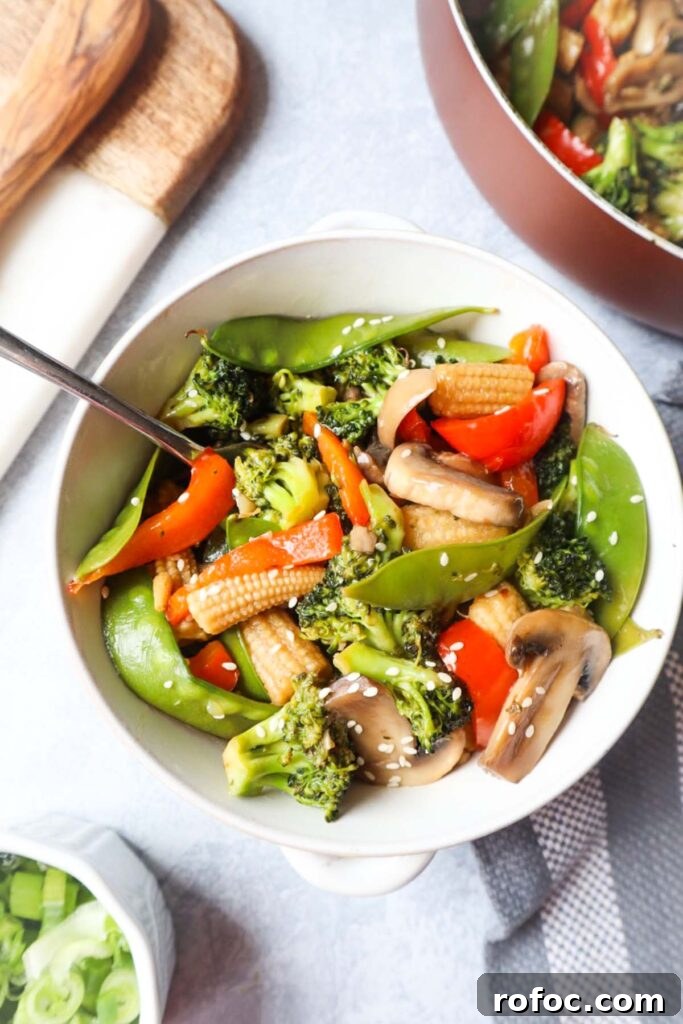 Pad Pak Thai (Pad Pak Ruam) — Classic Thai Mixed Vegetable Stir-Fry 2 white bowl with pad pad thai which contains broccoli, snow peas, red bell peppers, mushrooms, carrot topped with sesame seeds