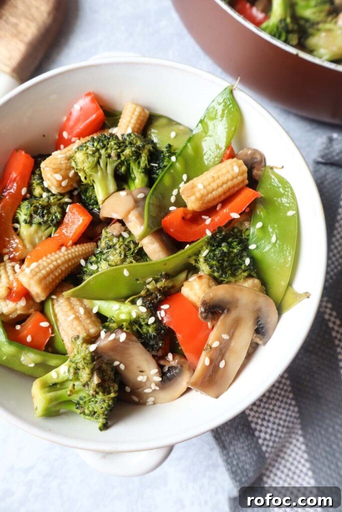 Pad Pak Thai (Pad Pak Ruam) — Classic Thai Mixed Vegetable Stir-Fry 3 white bowl with pad pad thai which contains broccoli, snow peas, red bell peppers, mushrooms, carrot topped with sesame seeds