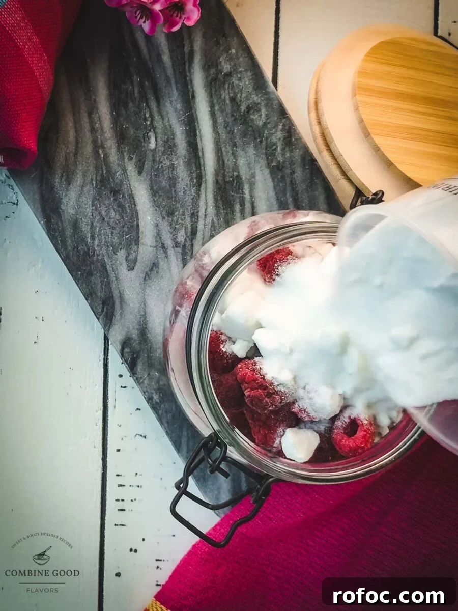 No-Cook Homemade Raspberry Syrup Recipe for Fresh, Intense Flavor 4 Filling the granulated sugar into the preserving jar filled with raspberries.