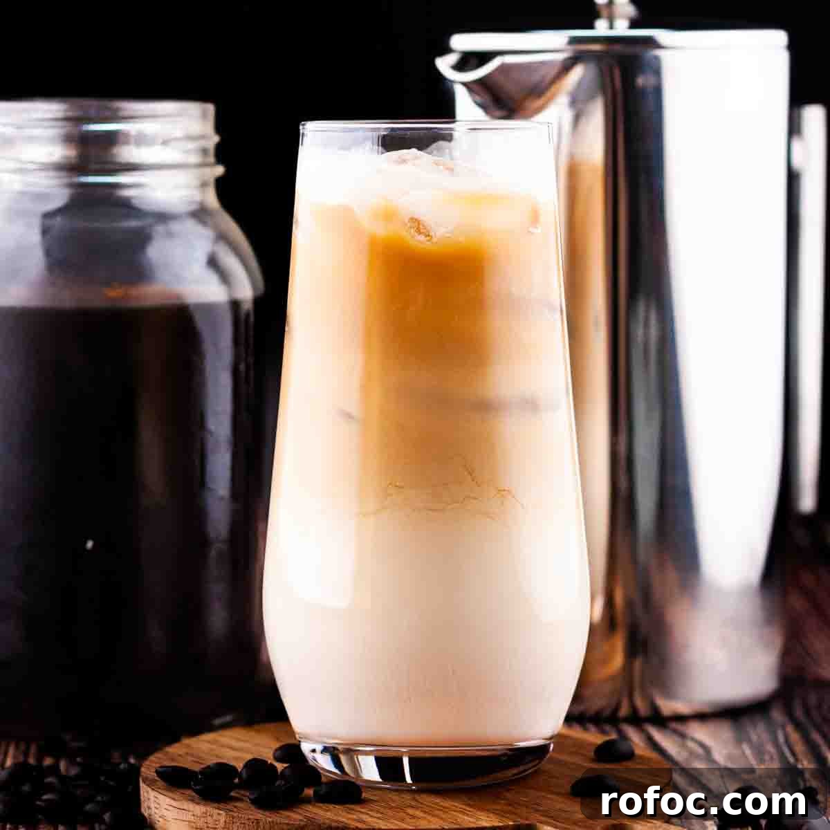 Homemade Vanilla Sweet Cream Cold Brew Recipe You’ll Love 13 A tall glass of sweet cream cold brew with a jar of cold brew concentrate and a French press in the background.