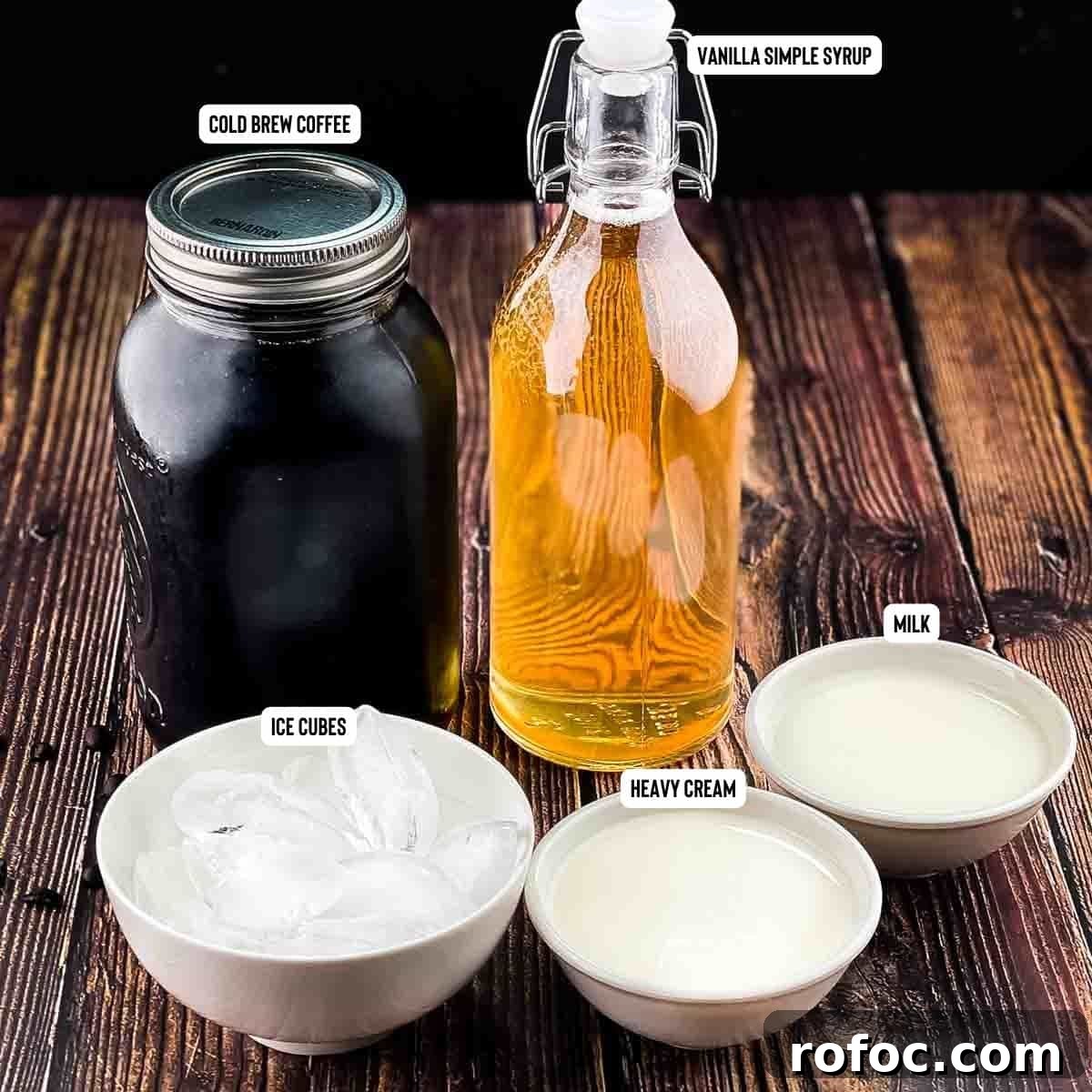 Homemade Vanilla Sweet Cream Cold Brew Recipe You’ll Love 3 Ingredients needed to make vanilla sweet cream cold brew measured out and placed on a wooden table.