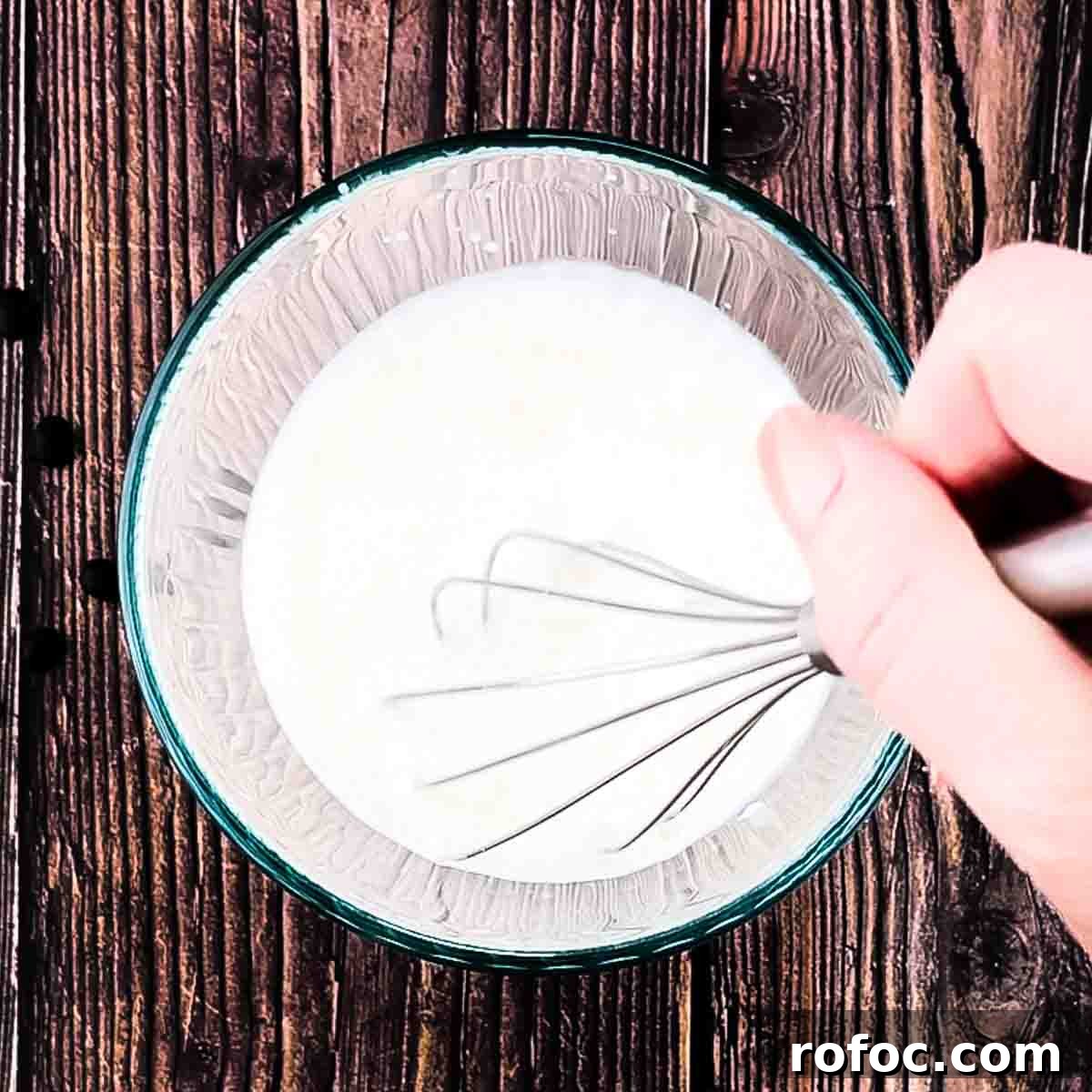 Homemade Vanilla Sweet Cream Cold Brew Recipe You’ll Love 9 A whisk mixing the ingredients in a glass bowl for the vanilla sweet cream.