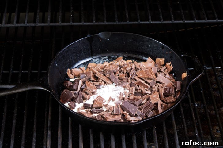 Traeger Smores Dip Recipe for Campfire-Style Desserts 6 Melting chocolate and cream in a skillet on a grill.